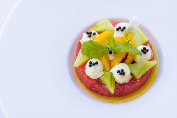 Salada de frutas tropicais com frutas de dragão, melancia e mamão laranja em fundo branco e elegante. Dieta saudável, café da manhã em hotel resort de luxo. Frutos veganos gourmet - Foto, Imagem