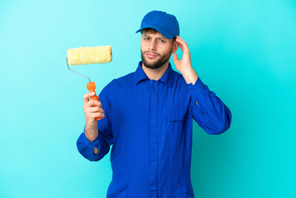 Malíř běloch muž izolované na modrém pozadí s pochybnostmi - Fotografie, Obrázek
