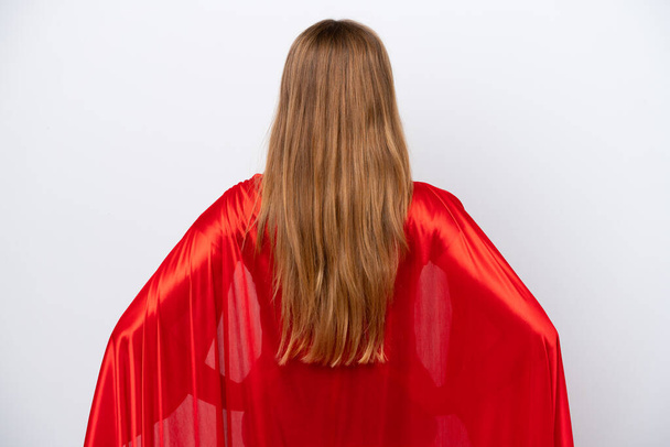Junge kaukasische Frau isoliert auf weißem Hintergrund im Superheldenkostüm in Rückenlage - Foto, Bild