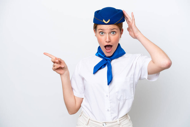 Airplane stewardess woman isolated on white background surprised and pointing finger to the side - Фото, изображение