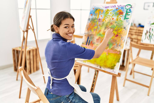 Jeune femme latine souriant dessin confiant au studio d'art - Photo, image