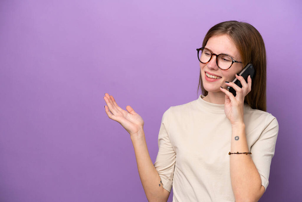 Mladá anglická žena izolované na fialovém pozadí vedení konverzace s mobilním telefonem s někým - Fotografie, Obrázek
