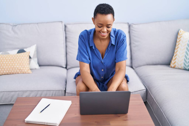 African american woman using laptop sitting on sofa at home - Fotoğraf, Görsel