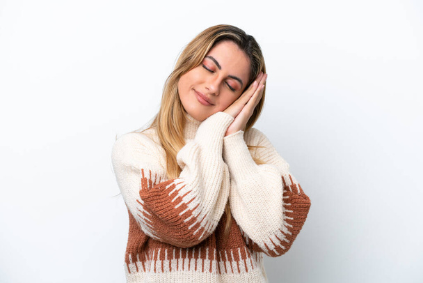 Young caucasian woman isolated on white background making sleep gesture in dorable expression - Φωτογραφία, εικόνα