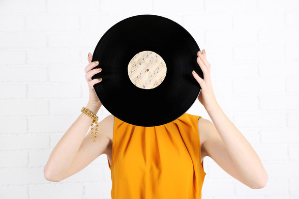 Young woman holding retro record - Foto, Imagen