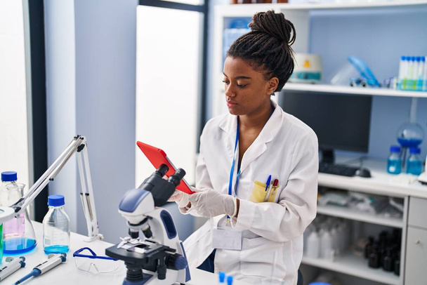 アフリカ系アメリカ人女性科学者が実験室でタッチパッドを使って - 写真・画像
