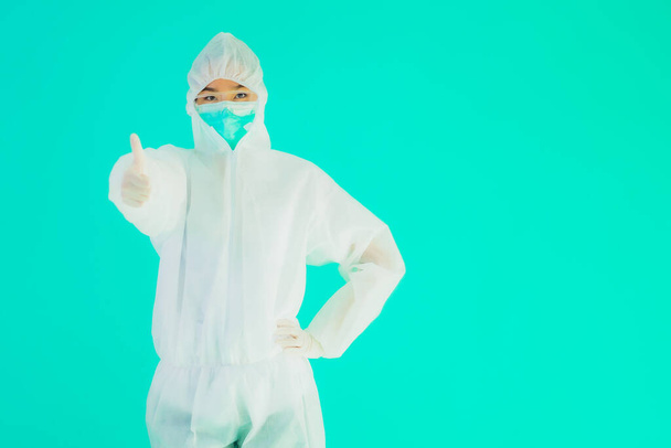 Portret mooie jonge aziatische arts vrouw dragen ppe of persoonlijke beschermingsmiddelen voor bescherming tegen coronavirus of covid19 op blauw geïsoleerde achtergrond - Foto, afbeelding