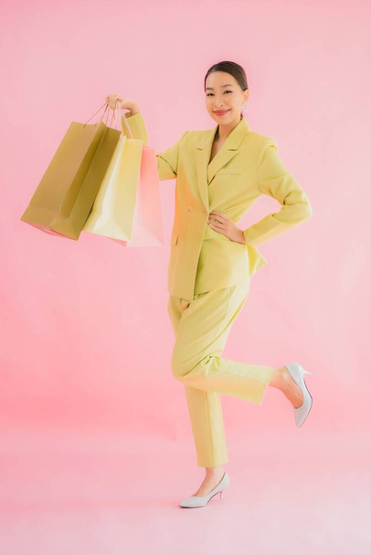 Portrait beautiful young asian business woman with shopping bag on color isolated background - Fotoğraf, Görsel