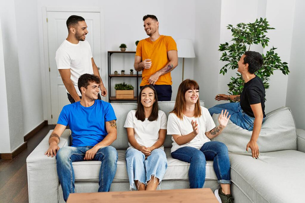 Група молодих друзів, посміхаючись, щасливо сидить на дивані вдома
. - Фото, зображення