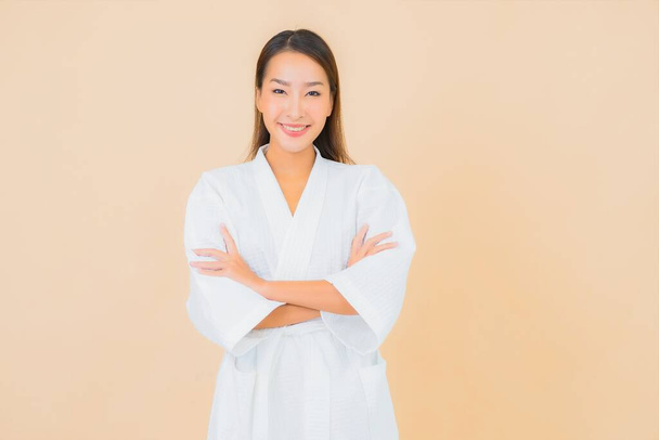 Portrait beautiful young asian woman wear bathrobe with smile on color background - Foto, Imagem