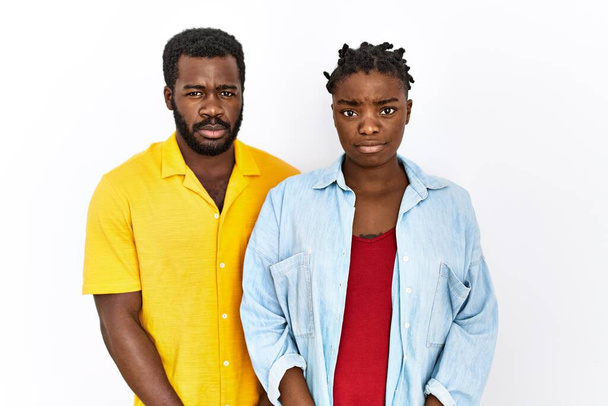Een jong Afrikaans-Amerikaans echtpaar draagt nonchalante kleren... sceptisch en nerveus, fronsend van streek vanwege het probleem. negatieve persoon.  - Foto, afbeelding