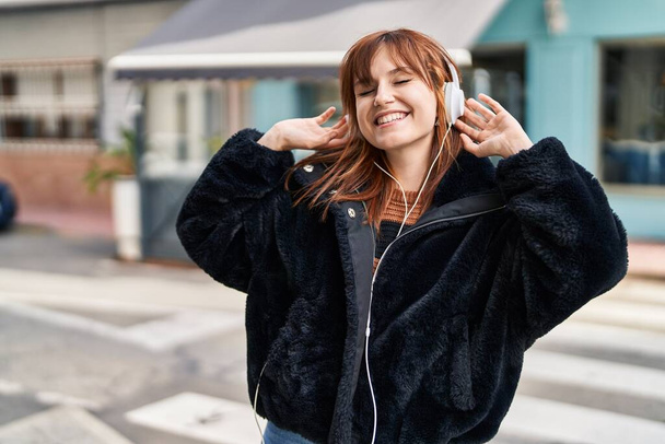 Mujer joven escuchando música y bailando en la calle - Foto, Imagen