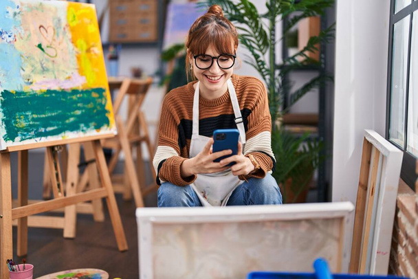 Mladá žena umělec pomocí smartphone v art studio - Fotografie, Obrázek