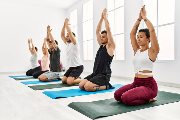 Gruppe junger Spanier trainiert konzentriert Yoga im Sportzentrum. - Foto, Bild