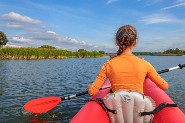 A girl in a red kayak is rowing along the Zdvizh River. Ukraine - Photo, Image