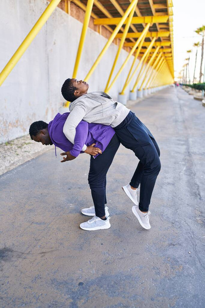 Пара мужчин и женщин в спортивной одежде, растянувшейся на улице - Фото, изображение