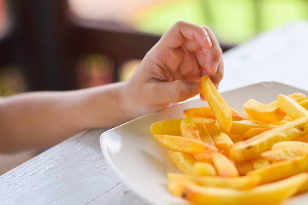 child eating french fries or potato chips. - Foto, Imagen