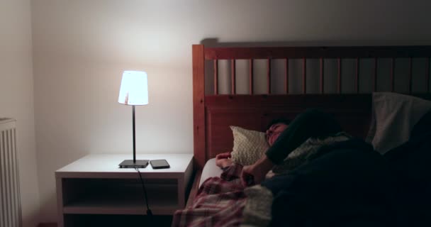 O homem acorda a meio da noite incapaz de dormir. Frustrado homem esfrega os olhos sofrendo de insônia em 4K - Filmagem, Vídeo
