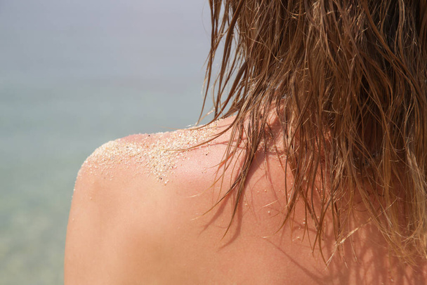 Frauenhaare am Strand. Nasse Haare Nahaufnahme Bild. Haarschäden durch salziges Meerwasser und Sonne, sommerliches Haarpflegekonzept. - Foto, Bild