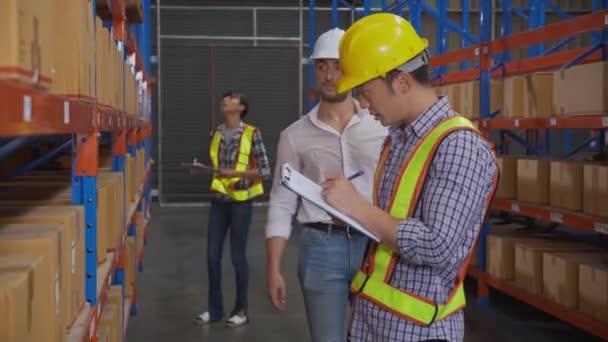 Jonge man en vrouw werknemer controleren voorraad en inspectie met document op klembord, terwijl manager klagen in het magazijn in de fabriek, werknemer werkfout bij magazijn, logistiek en lading. - Video