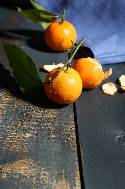 Juicy ripe tangerines with leaves on wooden table  - Φωτογραφία, εικόνα