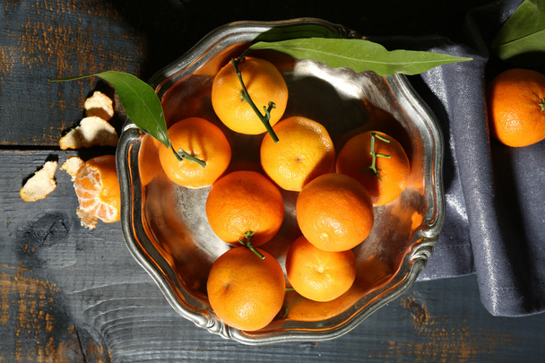 Juicy ripe tangerines with leaves on wooden table  - Zdjęcie, obraz