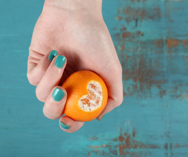Hand holding ripe tangerine, close up - Fotó, kép