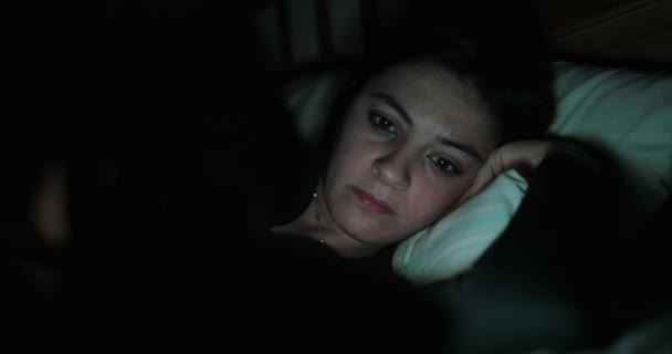 Mladá žena v posteli s smartphone. Ženy hrají na mobilní zařízení před spaním - Záběry, video
