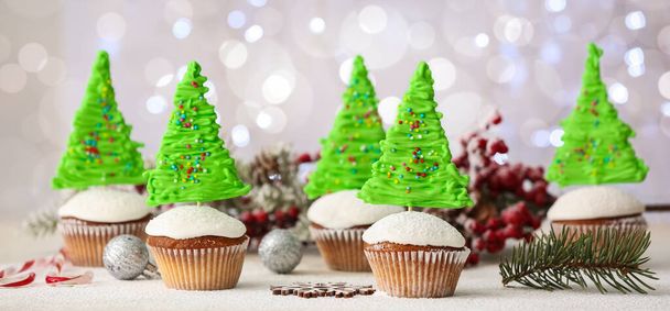 Leckere Weihnachts-Cupcakes und Dekorationen auf hellem Hintergrund - Foto, Bild