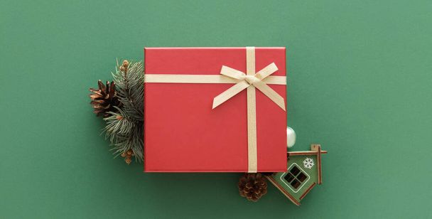 Χριστουγεννιάτικο κουτί δώρου και fir υποκατάστημα σε πράσινο φόντο - Φωτογραφία, εικόνα