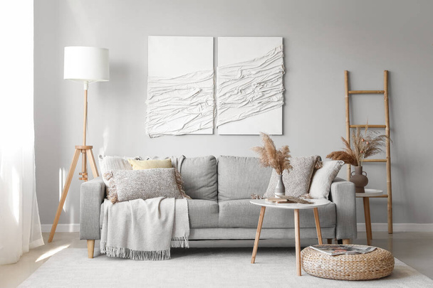 Belső tér modern nappali kanapéval, asztal és 3D textil műalkotások - Fotó, kép