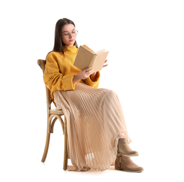 Schöne Frau im gelben Pullover liest Buch auf weißem Hintergrund - Foto, Bild