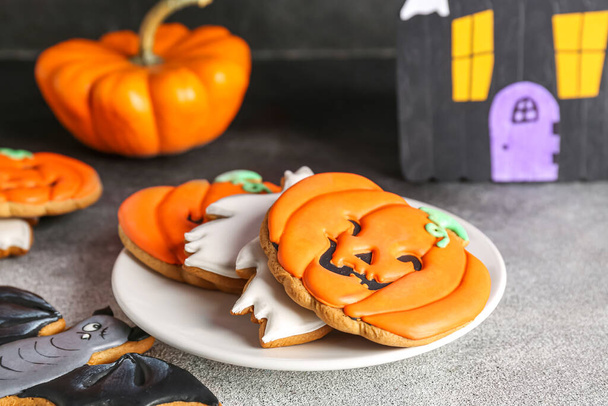 Bord met Halloween koekjes op zwart-wit achtergrond, close-up - Foto, afbeelding