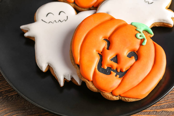 Plate with tasty Halloween cookies on wooden background, closeup - Photo, Image