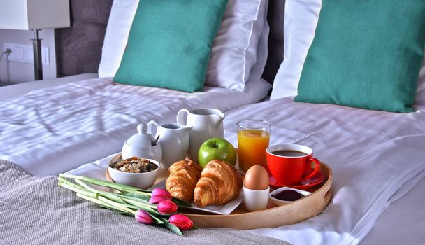 Πρωινό στο δίσκο στο κρεβάτι στο δωμάτιο του ξενοδοχείου.  - Φωτογραφία, εικόνα