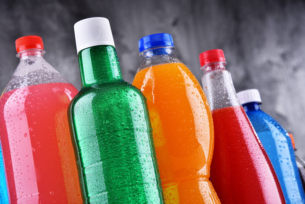 Пластиковые бутылки газированных напитков различных цветов - Фото, изображение