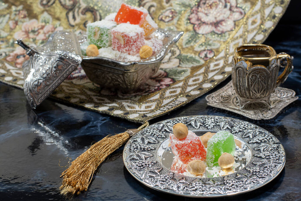 Lokum, türkisches Vergnügen eine türkische weiche Süßigkeit mit silbernem türkischen Kaffee. Pokale. auf weißem Hintergrund . - Foto, Bild