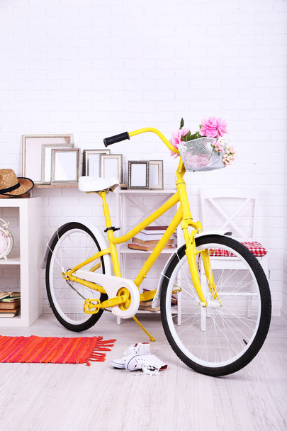 Yellow retro bicycle in spacious bright room - Foto, afbeelding
