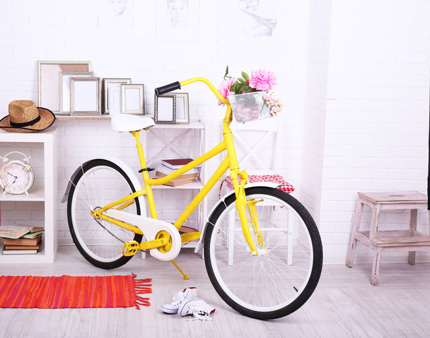 Yellow retro bicycle in spacious bright room - 写真・画像