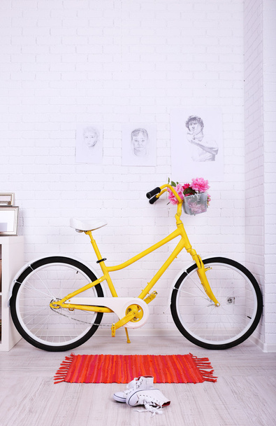Yellow retro bicycle in spacious bright room - Foto, afbeelding