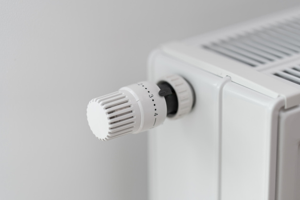 Le régulateur de thermostat, qui règle la température du radiateur de chauffage ambiant, est réglé sur une valeur moyenne. Allumage du chauffage en mode économie de 50 % en saison froide. - Photo, image