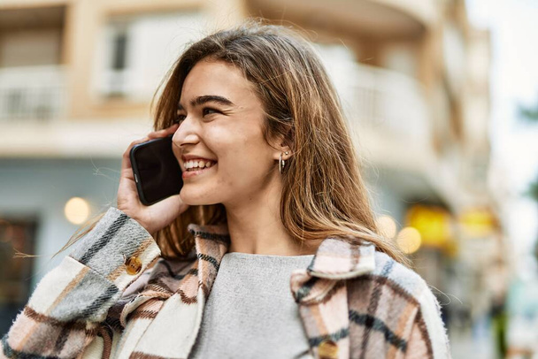 Mujer rubia joven hablando en el teléfono inteligente en la calle - Foto, Imagen