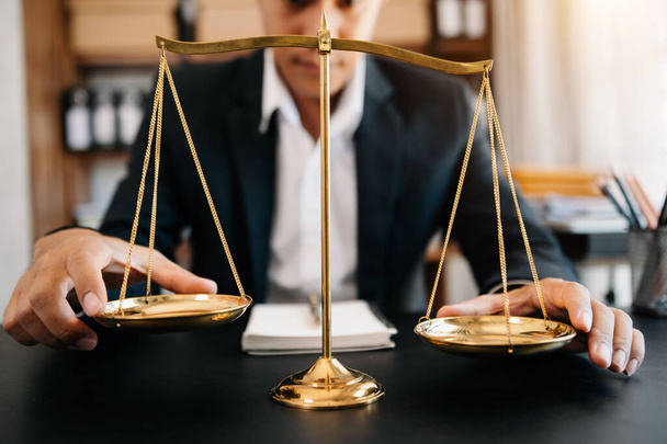 Male lawyer in office at desk table with brass scale. justice and law concept - Photo, image