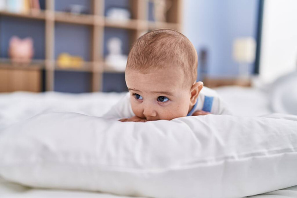 愛らしい赤ちゃんリラックスしたベッドルームでベッドの上に横たわる - 写真・画像