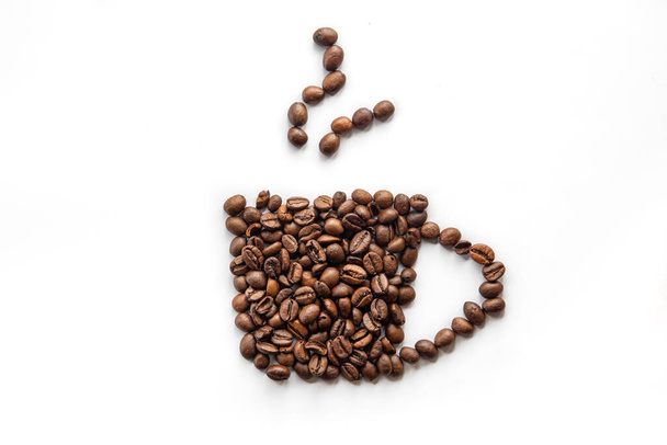 Стилізована чашка кави з кавових зерен на білому фоні
. - Фото, зображення