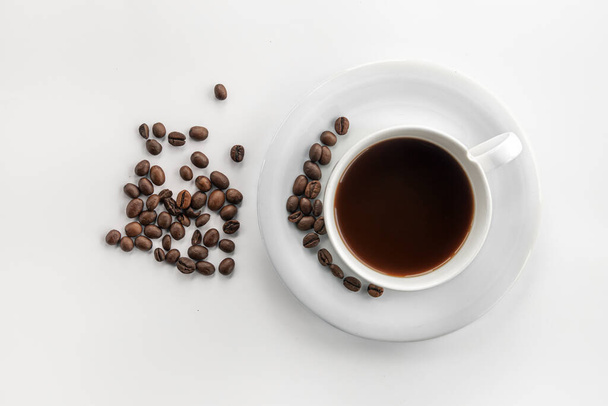 Kopje koffie en koffiebonen, plat op een witte achtergrond. - Foto, afbeelding