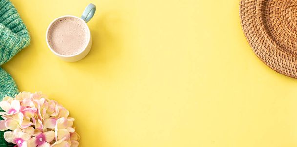 Весняно-жовтий фон з чашкою кави, квітами та в'язаним елементом, плоский простір, копіювання
. - Фото, зображення