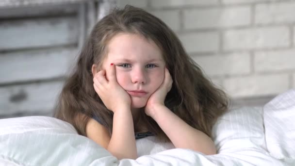 Enfant en colère fille couchée sur le lit couverture couverte et refuse de dormir - Séquence, vidéo