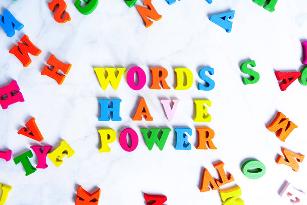 WORDS HAVE POWER lettering made from multicolored wooden characters arranged on a gray background. - Fotografie, Obrázek