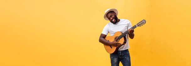Täyspitkä kuva innostunut taiteellinen mies soittaa kitaraa rento sviitti. Eristetty keltaisella pohjalla
 - Valokuva, kuva